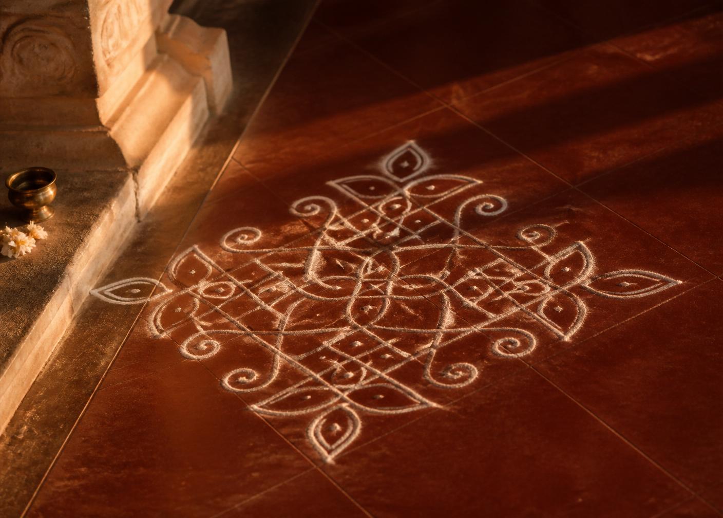 A hand-drawn kolam in white rice flour